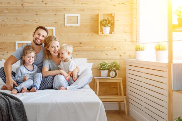 Счастливая семья мать отец и дети дочь и сын в постели — стоковое фото