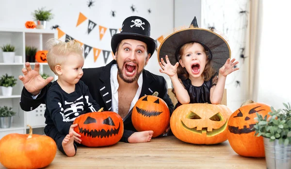 Family father and children in costumes   to halloween with pumpk — Stock Photo, Image