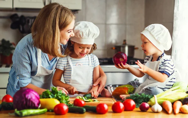 Gesunde Ernährung. glückliche Familienmutter und Kinder bereitet Gemüse zu — Stockfoto