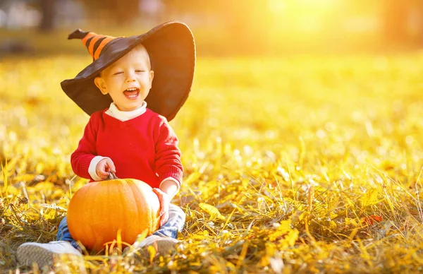 Baby boy with pumpkin outdoors in halloween — Stock Photo, Image