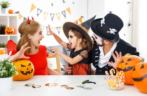 Família feliz em trajes para o Halloween em casa — Fotografia de Stock