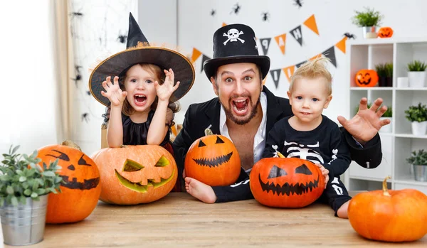Familie vader en kinderen in kostuums voor halloween met pumpk — Stockfoto