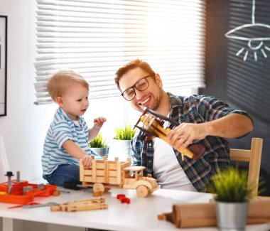 Mutlu aile baba ve oğlu yürümeye başlayan çocuk zanaat ahşap ve pla arabadan toplamak