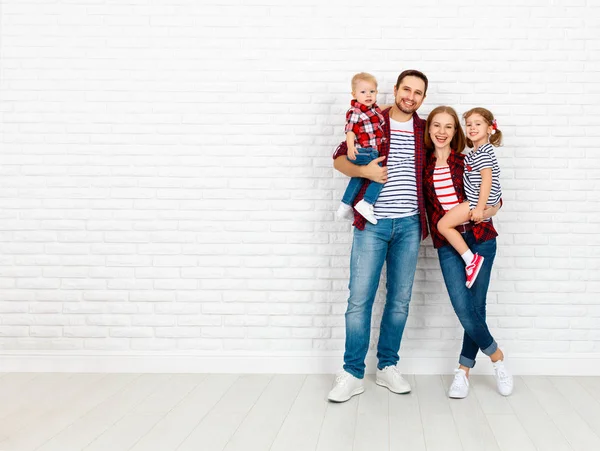 Felice famiglia madre, padre, figlio, figlia su un muro bianco vuoto — Foto Stock