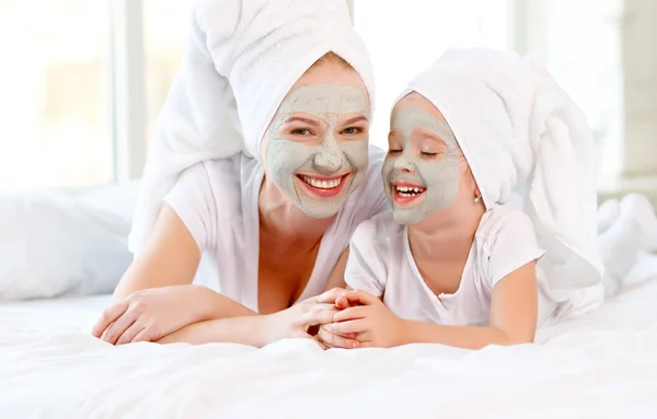 Gelukkige familie moeder en peuter maken gezicht huid mas — Stockfoto