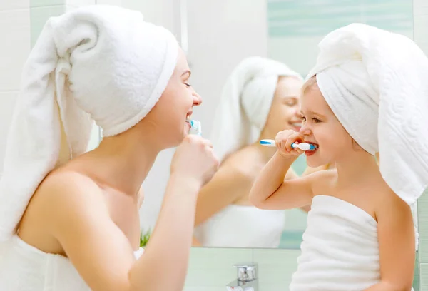 Madre e hija se cepillan los dientes con un cepillo de dientes — Foto de Stock