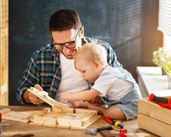 Father and toddler son carved of wood in carpentry worksho