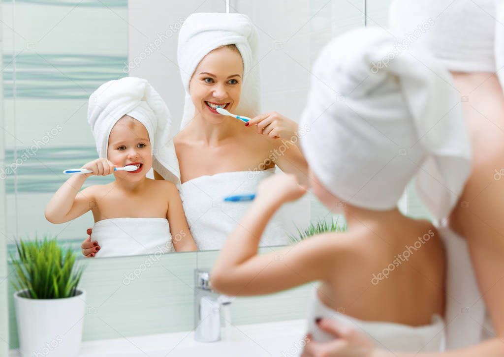 Mother and child daughter brush their teeth with  toothbrush