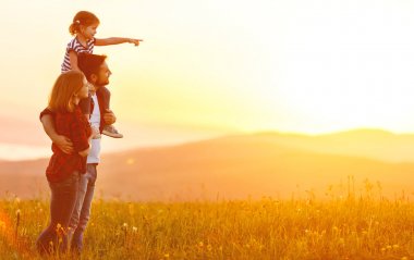 Mutlu bir aile: anne baba ve çocuk kız sunse üzerinde