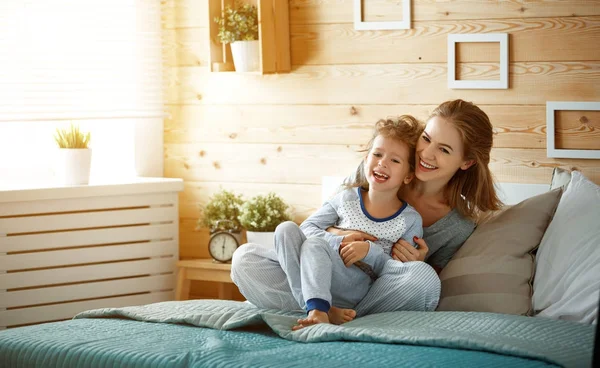 Yatakta gülerek mutlu aile anne ve çocuk kızı