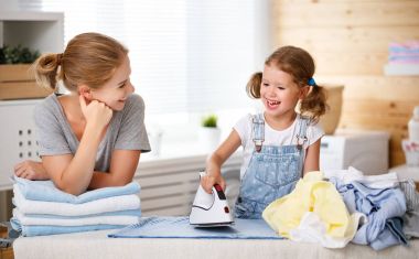 Mutlu aile anne ev hanımı ve çocuk kız elbise Ütü