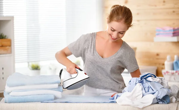 Mujer feliz ama de casa planchar ropa en la lavandería en hom — Foto de Stock