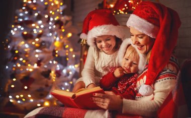 aile anne ve çocuk Noel'de firep bir kitap okumak