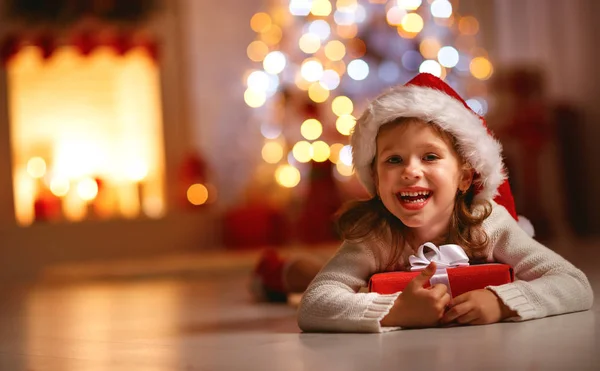 Glad skrattande barn flicka med julklapp som på hom — Stockfoto