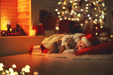 kız çocuk Noel arifesinde ağacın yanında uykuya daldı
