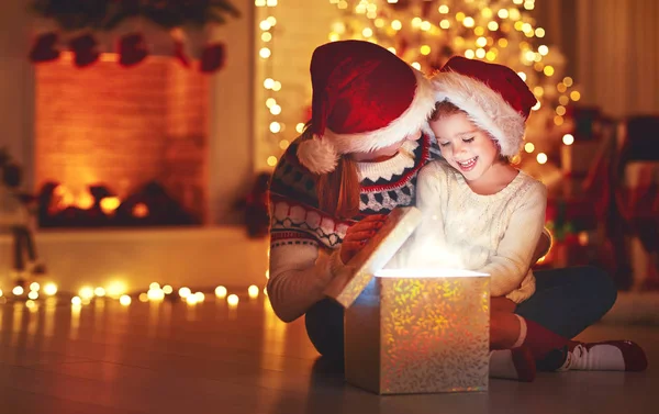 Feliz Natal! família mãe e criança com presente mágico em ho — Fotografia de Stock