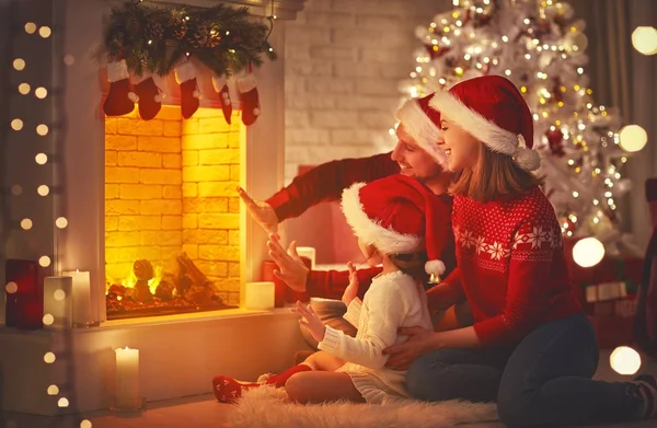 Família feliz sentado à lareira no Natal Ev — Fotografia de Stock