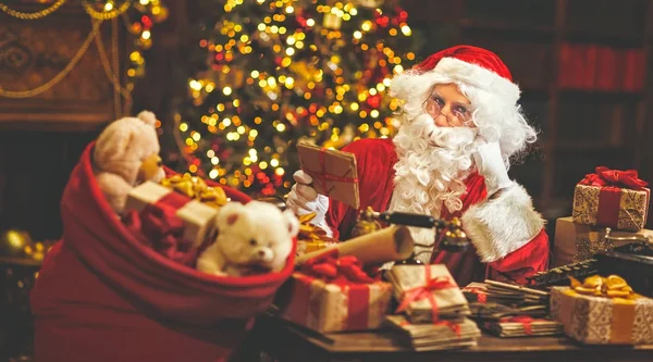 Santa Claus aan balie met letters en Kerstcadeaus — Stockfoto