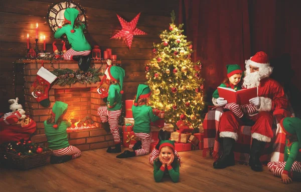 Santa Claus a malé elfové před Vánocemi v jeho hous — Stock fotografie