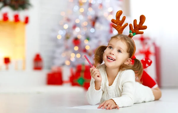 크리스마스 트리 근처 산타 집으로 편지를 쓰는 아이 소녀 — 스톡 사진
