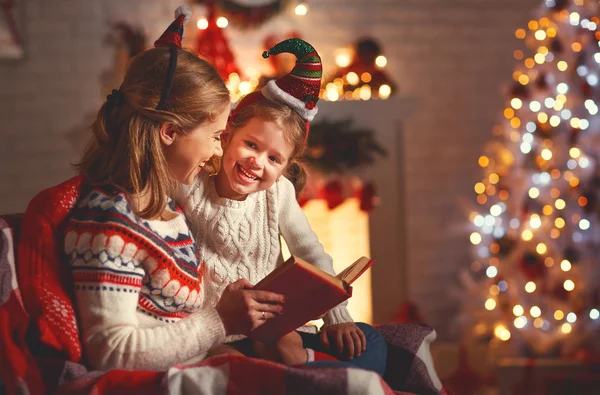 Kerstavond. familie-moeder en kind dochter lezen magic bo — Stockfoto