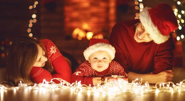 Feliz família mãe pai e bebê na árvore de natal em casa — Fotografia de Stock