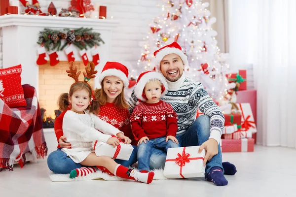 Ευτυχισμένη οικογένεια μητέρα ο πατέρας και τα παιδιά στο πρωί Χριστουγέννων — Φωτογραφία Αρχείου
