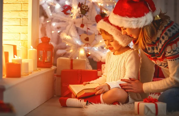 Kerstavond. familie-moeder en kind dochter lezen magic bo — Stockfoto
