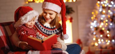 Noel arifesi. aile anne ve bebek okuma sihirli kitap evde