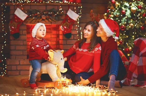 Lycklig familj mor far och barn på julgran hemma — Stockfoto