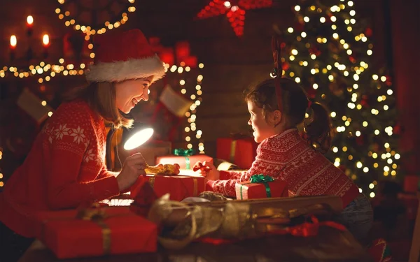 Lyckliga familjen mor och barn packa julklappar — Stockfoto