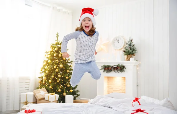 Ευτυχισμένο παιδί κορίτσι άλματα στο κρεβάτι στο πρωί Χριστουγέννων — Φωτογραφία Αρχείου