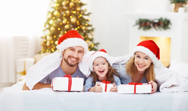 Lyckliga familjen mamma, Pappa och barn på juldagsmorgonen i sängen — Stockfoto