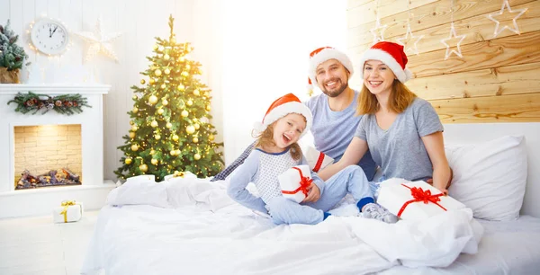 Gelukkig gezin vader moeder en kind op kerstochtend in bed — Stockfoto