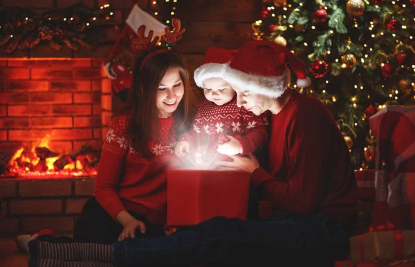 ¡Feliz Navidad! familia madre padre y bebé con un regalo mágico —  Fotos de Stock