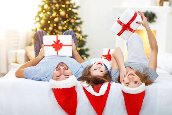 Feliz familia madre padre e hijo en la mañana de Navidad en la cama —  Fotos de Stock