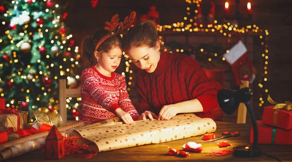 Família feliz mãe e criança embalar presentes de Natal — Fotografia de Stock