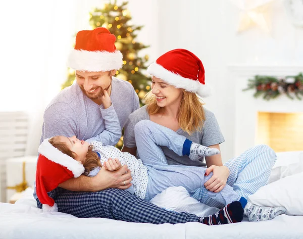 Lyckliga familjen mamma, Pappa och barn på juldagsmorgonen i sängen — Stockfoto