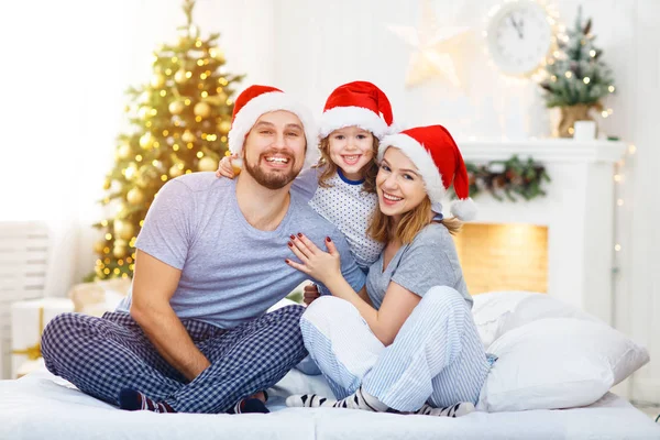 Feliz familia madre padre e hijo en la mañana de Navidad en la cama — Foto de Stock