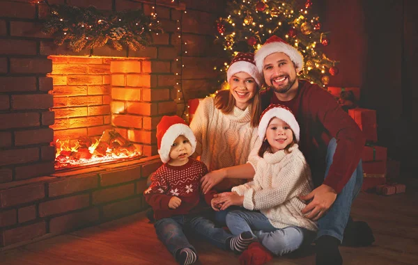 Šťastná rodina sedí u krbu na Štědrý den — Stock fotografie