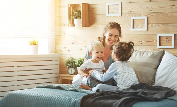 Felice famiglia madre e figli a letto — Foto Stock