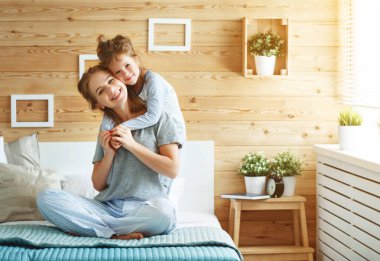 Yatakta gülerek mutlu aile anne ve çocuk kızı