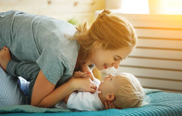 Mutlu aile anne ve bebek evlat yürümeye başlayan çocuk yatakta gülüyor — Stok fotoğraf