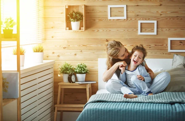 Felice famiglia madre e figlia bambina ridendo a letto — Foto Stock