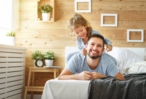 Happy family father and   daughter laughing and playing in be — Stock Photo, Image