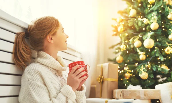 Femme heureuse avec une tasse de thé près de l'arbre de Noël — Photo