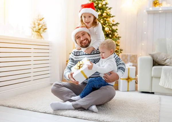 Pai de família feliz e crianças brincando perto da árvore de Natal — Fotografia de Stock