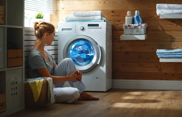 Mujer ama de casa feliz en la sala de lavandería con lavadora —  Fotos de Stock