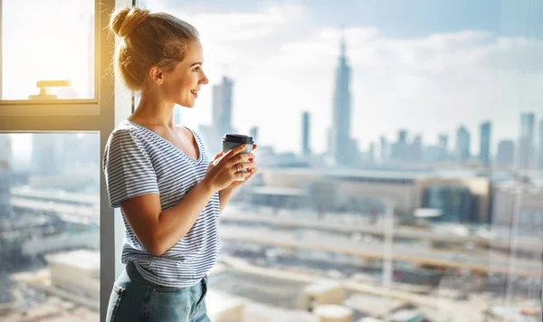 Gelukkig jonge vrouw drinkt koffie in de ochtend bij raam — Stockfoto