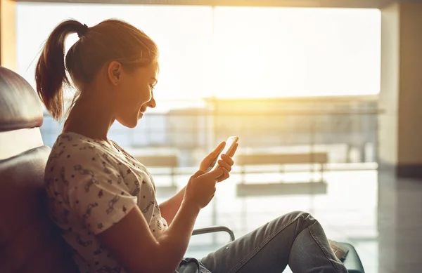 Femme parlant au téléphone attendant de voler à l'aéroport à la fenêtre — Photo